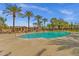 Community pool surrounded by lush landscaping including mature palm trees and views of the community buildings at 3863 S Posse Trl, Gilbert, AZ 85297