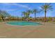 Large community pool surrounded by lush landscaping including mature palm trees and views of the community buildings at 3863 S Posse Trl, Gilbert, AZ 85297