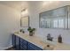 Bathroom featuring dual sinks, a large mirror, black fixtures, and a separate shower at 40759 W Bravo Dr, Maricopa, AZ 85138