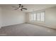 Spacious bedroom with neutral carpet, recessed lighting, ceiling fan, and shuttered windows at 40759 W Bravo Dr, Maricopa, AZ 85138
