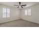 This bedroom features carpeted floors, a ceiling fan, and shuttered windows at 40759 W Bravo Dr, Maricopa, AZ 85138
