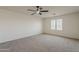 Light-filled bedroom with carpet, modern ceiling fan, and window with bright shutters at 40759 W Bravo Dr, Maricopa, AZ 85138