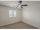 This bedroom has a modern ceiling fan and a window with plantation shutters at 40759 W Bravo Dr, Maricopa, AZ 85138