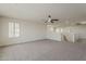 Large bonus room with soft carpet, ceiling fan, and window featuring modern shutters at 40759 W Bravo Dr, Maricopa, AZ 85138