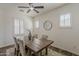 Bright dining room features a rustic wood table, tufted chairs, and three sunny windows at 40759 W Bravo Dr, Maricopa, AZ 85138