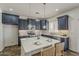 Island kitchen featuring modern pendant lights, stainless appliances, and stylish seating at 40759 W Bravo Dr, Maricopa, AZ 85138