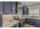 Modern kitchen with navy cabinets, stainless appliances, and quartz countertops at 40759 W Bravo Dr, Maricopa, AZ 85138