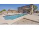Beautiful backyard with a sparkling swimming pool, desert landscaping, and a covered patio at 40759 W Bravo Dr, Maricopa, AZ 85138