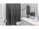 This updated bathroom features modern vanity, updated faucet, and a shower with a modern shower curtain at 4341 W Pelotazo Way, San Tan Valley, AZ 85144
