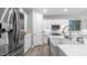 Open kitchen showcasing stainless appliances, white cabinetry, a kitchen island, and ample lighting at 4341 W Pelotazo Way, San Tan Valley, AZ 85144