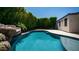 A backyard pool with a rock waterfall feature and privacy landscaping at 4341 W Pelotazo Way, San Tan Valley, AZ 85144