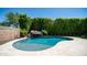 Beautiful pool with rock waterfall feature surrounded by lush landscaping and a light tile deck at 4341 W Pelotazo Way, San Tan Valley, AZ 85144