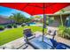 Relaxing backyard featuring a patio set under a red umbrella, manicured lawn and a swimming pool at 6731 S 37Th Dr, Phoenix, AZ 85041