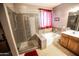 Modern bathroom featuring a glass-enclosed shower with tiled walls and floor, plus a soaking tub and vanity at 6731 S 37Th Dr, Phoenix, AZ 85041