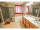 Elegant bathroom featuring a glass-enclosed shower, tub, and dual-sink vanity at 6731 S 37Th Dr, Phoenix, AZ 85041