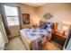 Bright bedroom with queen bed, side tables and lamps, and a view of the outside at 6731 S 37Th Dr, Phoenix, AZ 85041