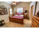 Warm bedroom showcasing a rustic wooden bed frame, vaulted ceilings, and neutral decor at 6731 S 37Th Dr, Phoenix, AZ 85041