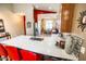 A gourmet kitchen island with a stainless sink, red bar stools, and a view to the dining room at 6731 S 37Th Dr, Phoenix, AZ 85041