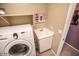 Functional laundry room with a washing machine, sink, and built-in shelf at 6731 S 37Th Dr, Phoenix, AZ 85041