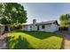 The house has a big backyard with lush green grass and a tall chimney at 717 W Manhatton Dr, Tempe, AZ 85282