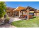 Inviting backyard featuring a covered patio, lush artificial grass, and a relaxing hot tub under a pergola at 7413 W Southgate Ave, Phoenix, AZ 85043