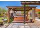 Relaxing backyard featuring a hot tub under a pergola surrounded by lush greenery and artificial grass at 7413 W Southgate Ave, Phoenix, AZ 85043