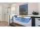 Bright bathroom featuring a large tub with jets, a separate shower, a window, and modern fixtures at 7413 W Southgate Ave, Phoenix, AZ 85043