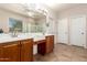 Bright bathroom featuring a double sink vanity, large mirror, separate shower and toilet rooms, and tile floors at 7413 W Southgate Ave, Phoenix, AZ 85043
