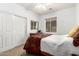 Cozy bedroom with a window, closet, ceiling fan, and bed dressed with a patterned blanket at 7413 W Southgate Ave, Phoenix, AZ 85043