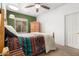 Bedroom featuring colored walls, a window, a bed, ceiling fan, and a wooden dresser at 7413 W Southgate Ave, Phoenix, AZ 85043