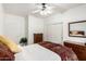 Bright bedroom featuring a ceiling fan, closet, white walls and a bed dressed with patterned blanket at 7413 W Southgate Ave, Phoenix, AZ 85043