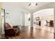 Open-concept living area with hardwood floors, chair, and archways to other rooms at 7413 W Southgate Ave, Phoenix, AZ 85043