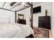 Elegant primary bedroom with canopy bed, wooden beams, and ensuite bathroom at 7413 W Southgate Ave, Phoenix, AZ 85043