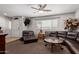Well-lit living room with neutral paint, ceiling fan, leather seating and carpet flooring at 7730 E Culver St, Mesa, AZ 85207