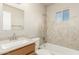 Bright bathroom featuring a single sink vanity, mirror, and tiled shower and tub combo at 840 N Acacia --, Mesa, AZ 85213