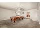 Spacious living room featuring a large pool table, neutral carpet, and direct access to the kitchen and a bonus seating area at 840 N Acacia --, Mesa, AZ 85213