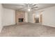 Large living room featuring a red brick fireplace, neutral walls and carpet, and direct access to the kitchen and bar at 840 N Acacia --, Mesa, AZ 85213