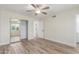 A small bedroom with a neutral palette, laminated flooring, closet with mirror doors and natural light from a window at 845 E Hampton Ave, Mesa, AZ 85204