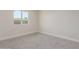 A small bedroom with a neutral palette, carpeted flooring, and natural light from a window at 845 E Hampton Ave, Mesa, AZ 85204