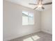 A small bedroom with a neutral palette, carpeted flooring, and natural light from a window at 845 E Hampton Ave, Mesa, AZ 85204