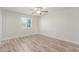 A small bedroom with a neutral palette, laminated flooring, and natural light from a window at 845 E Hampton Ave, Mesa, AZ 85204