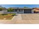Charming single story home featuring a spacious driveway, lawn and a low white brick wall at 845 E Hampton Ave, Mesa, AZ 85204