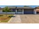 Charming single story home featuring a spacious driveway, lawn and a low white brick wall at 845 E Hampton Ave, Mesa, AZ 85204