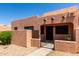 Inviting desert home featuring a stucco facade, secure gated entry, and shaded front porch with adobe accents at 8940 W Olive Ave # 59, Peoria, AZ 85345