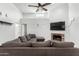 Light and airy living room featuring a cozy brick fireplace, a ceiling fan and neutral tones at 8940 W Olive Ave # 59, Peoria, AZ 85345