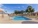 Community pool with clear blue water, lounge chairs, and well-maintained landscaping at 8940 W Olive Ave # 59, Peoria, AZ 85345