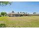 Wide-angle view of the backyard showcasing expansive lawn space, and back exterior with screened porch at 10431 W Roundelay Cir, Sun City, AZ 85351