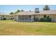 Spacious backyard featuring a well-kept lawn and the home's exterior with screened porch and side windows at 10431 W Roundelay Cir, Sun City, AZ 85351
