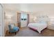 Bright bedroom with a comfortable bed, large window, and cozy blue chair at 10431 W Roundelay Cir, Sun City, AZ 85351