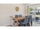 Bright dining room featuring a wooden table, stylish chairs, and sliding glass doors to an outdoor area at 10431 W Roundelay Cir, Sun City, AZ 85351
